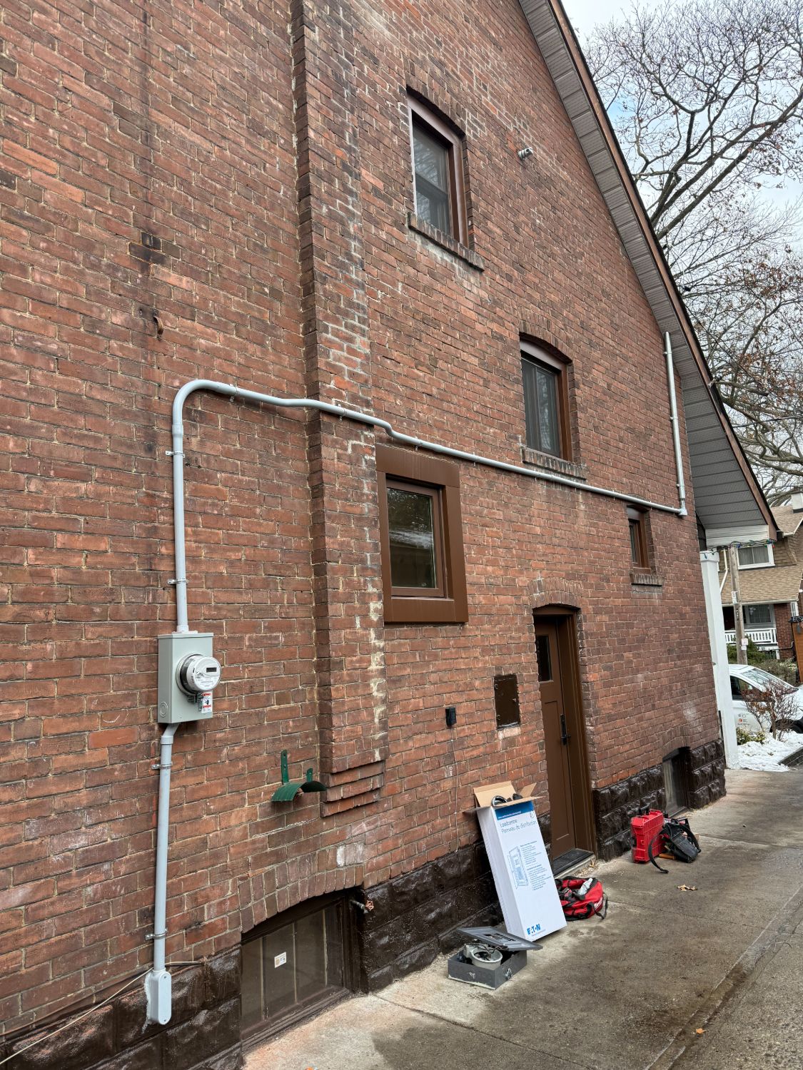 Complete 200A electrical service upgrade with new meter socket and conduit on Toronto brick home